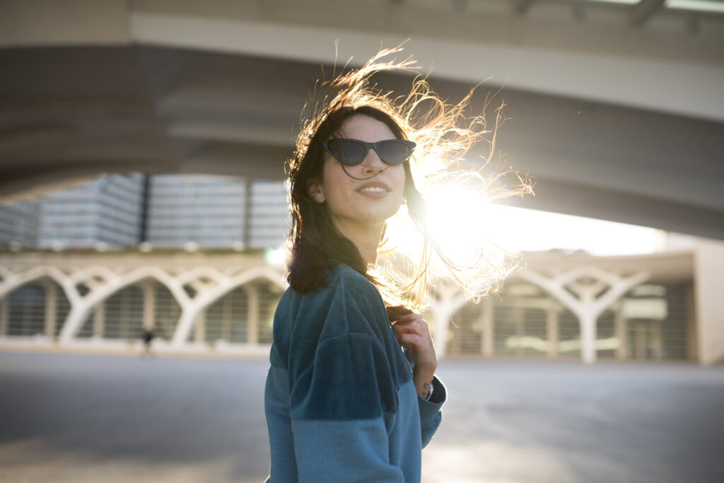 “Persona con gafas en el exterior cubriéndose del sol con incomodidad. Sensibilidad a la luz”